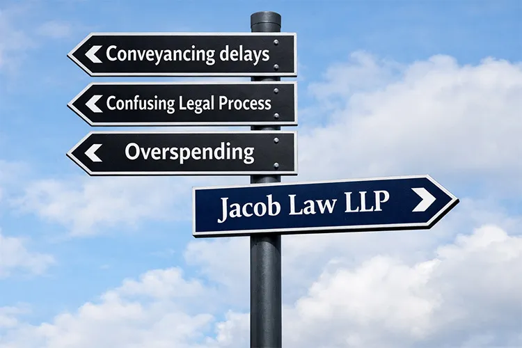 Signpost with arrows reading Conveyancing delays, Confusing Legal Process and Overspending, and one reading Jacob Law LLP